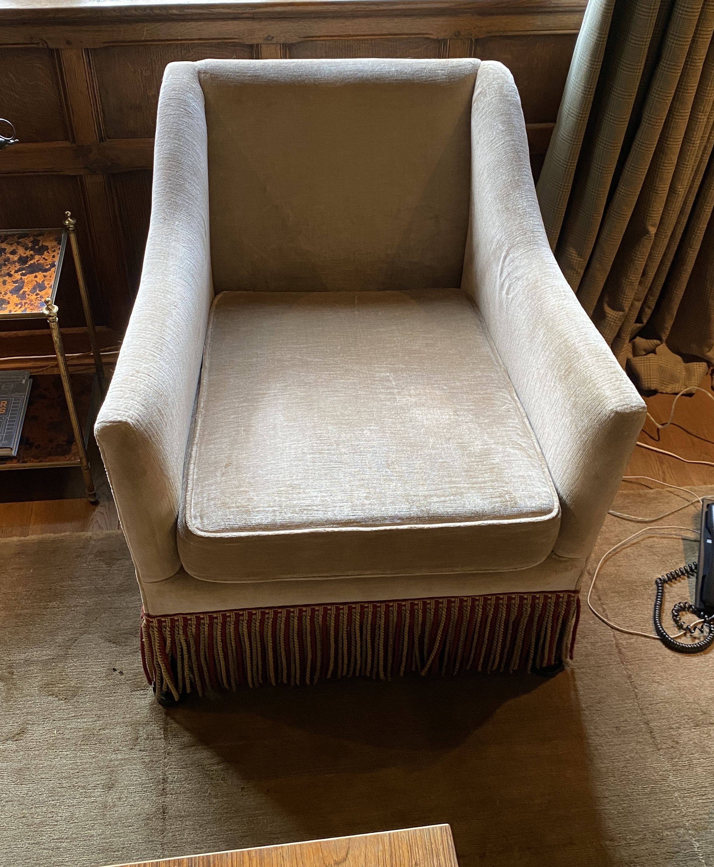 A pair of pale beige chenille armchairs, with tassle fringes, width 77cm depth 80cm